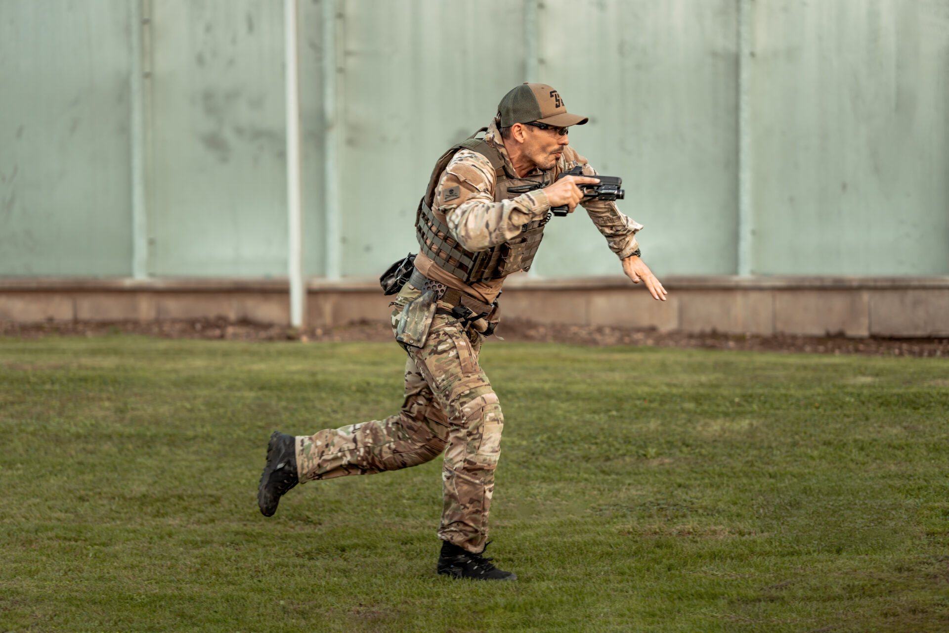 Střelec s pistolí v taktickém vybavení běžící do situace